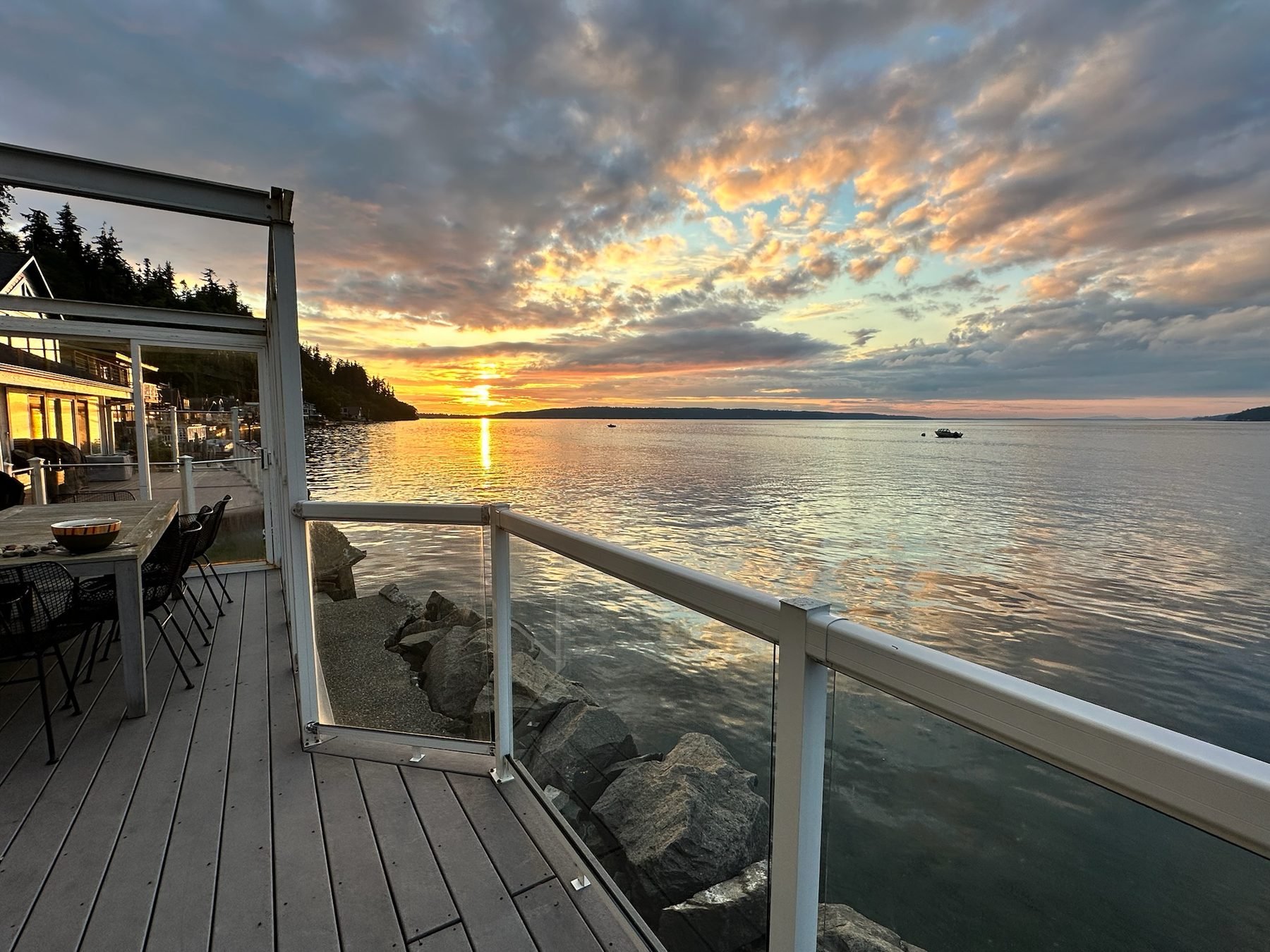 Sunset from the deck with water, rocks, and boats