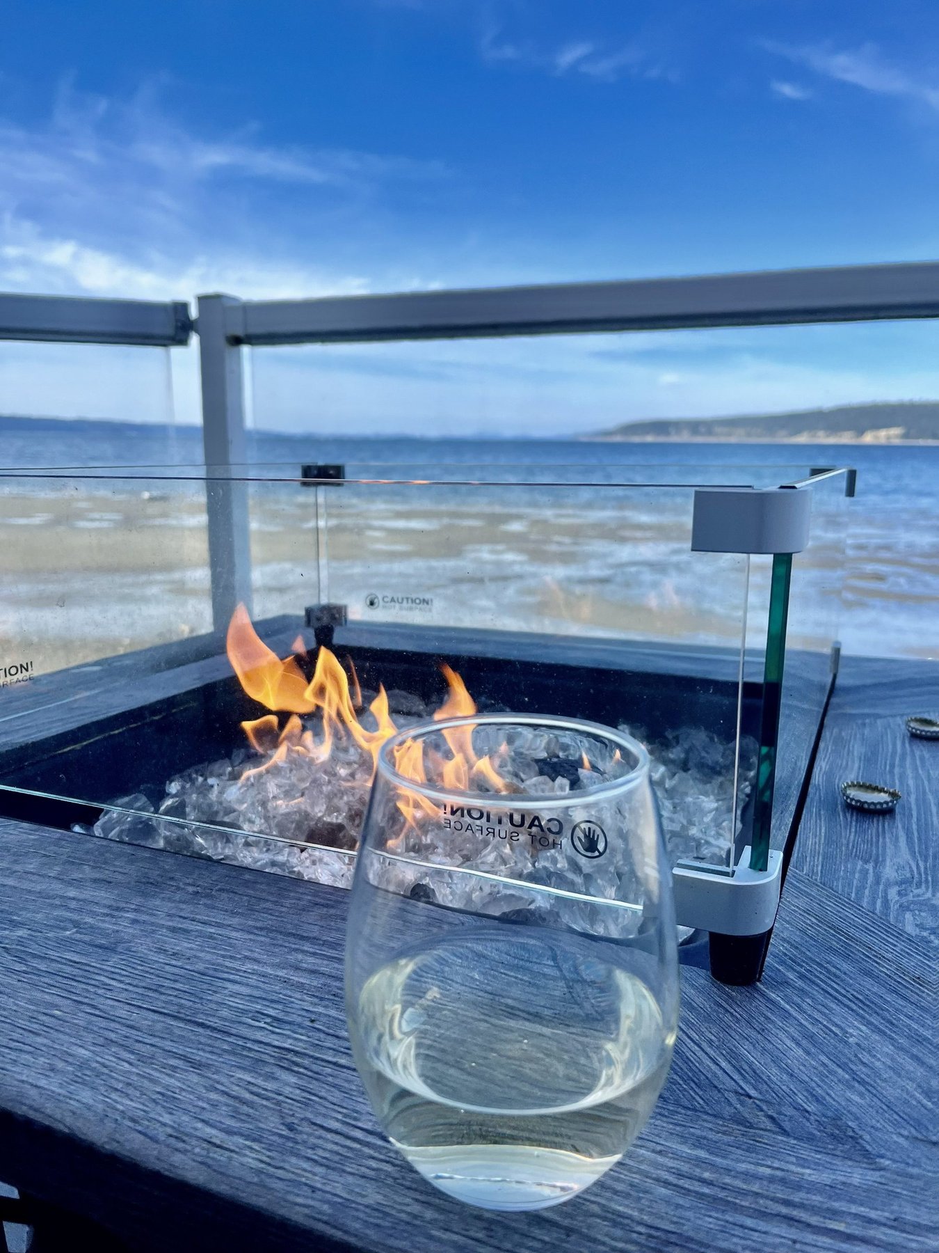 Wine glass beside the deck fire pit with water view
